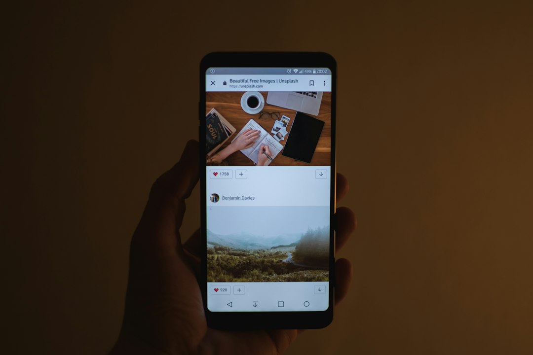A close-up overhead shot of a person's hand holding a smartphone, scrolling through online reviews for a real estate agent in a bright, clean setting.