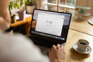 Person with a serious expression leans in to closely inspect a real estate agent's website on a laptop screen in a modern ...